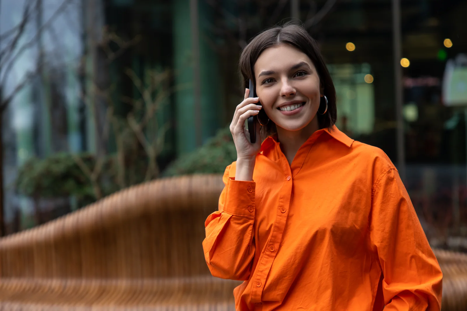 Mulher sorrindo ao telefone na rua