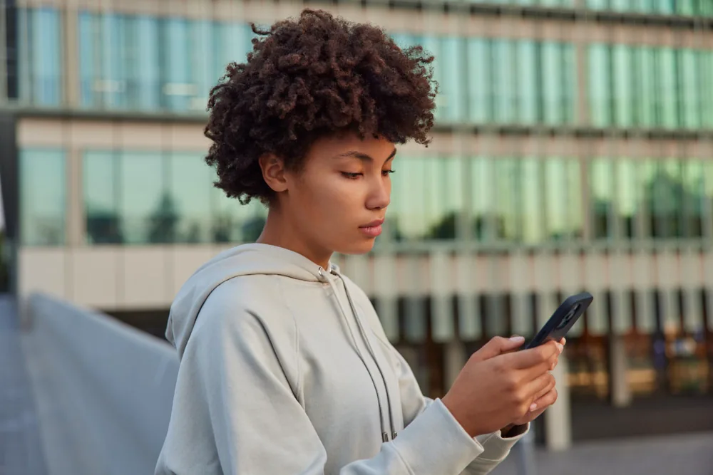 Mulher usando a Zuri pelo WhatsApp no celular